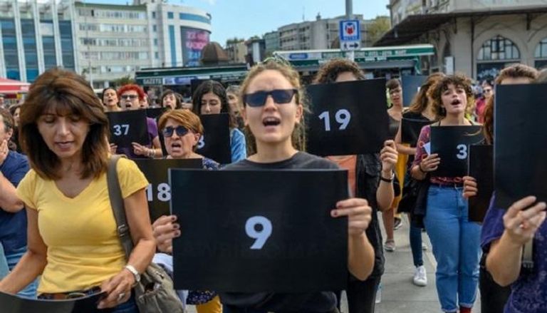 نساء يحملن علامات ترمز إلى قتل النساء خلال احتجاج في إسطنبول