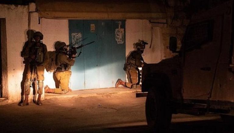 جنود الاحتلال يتأهبون لاعتقال فلسطينيين تتهمهم إسرائيل بتنفيذ هجمات