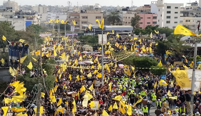 فلسطينية تتوشح بعلم حركة فتح وتحمل صورة الرئيس عباس