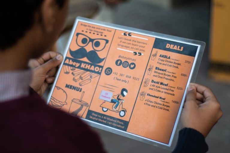 زبون يطلب الطعام بلغة الإشارة من أحد العاملين بالمطعم