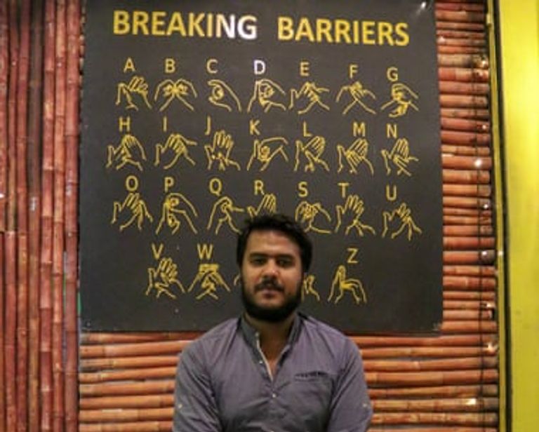 زبون يطلب الطعام بلغة الإشارة من أحد العاملين بالمطعم