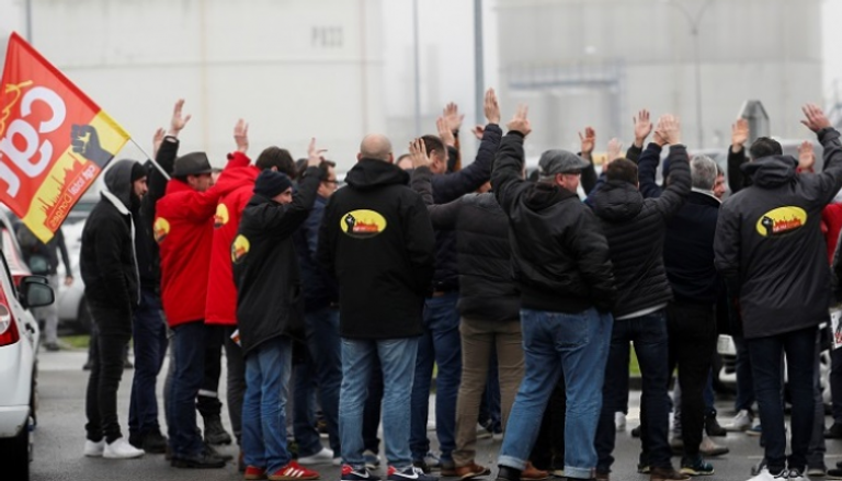 عمال شركة توتال يتجمعون أمام مصفاة النفط في دونجس- رويترز