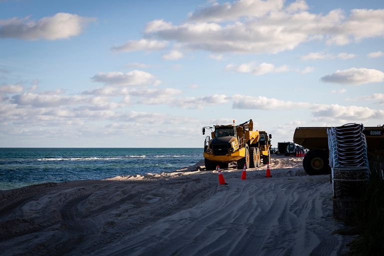 عشرات الشاحنات تفرغ أطنانا من الرمل الأبيض في ميامي بيتش