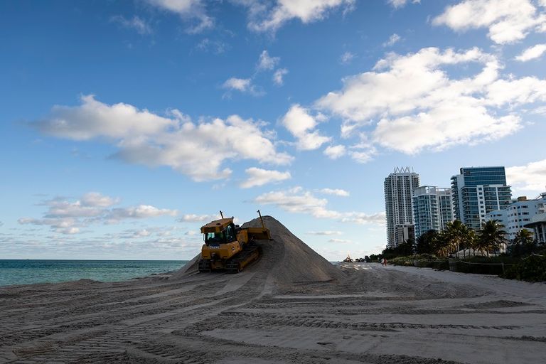 عشرات الشاحنات تفرغ أطنانا من الرمل الأبيض في ميامي بيتش