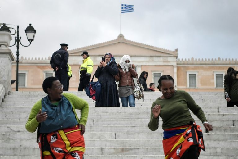 امرأة تجلس بالقرب من شعارات رفعت في تظاهرة لمناهضة العنف ضد النساء