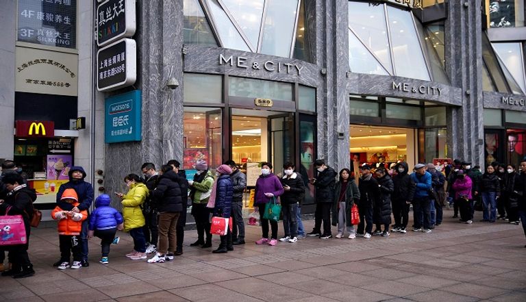 أشخاص يصطفون خارج صيدلية لشراء الأقنعة في شنغهاي