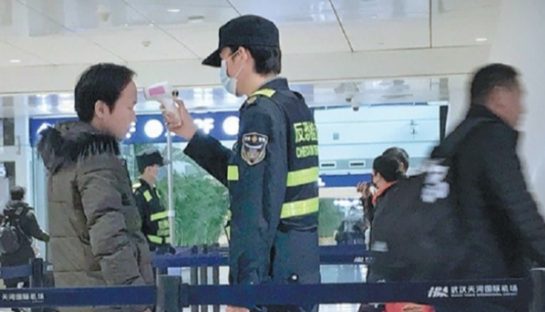 فحص أحد الركاب في مطار ووهان الصيني