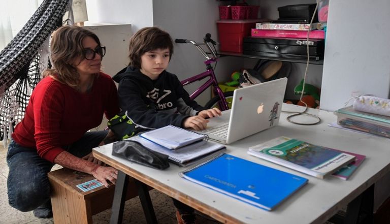 سينتيا بيرغولا تساعد طفلها على متابعة الدروس عبر الإنترنت