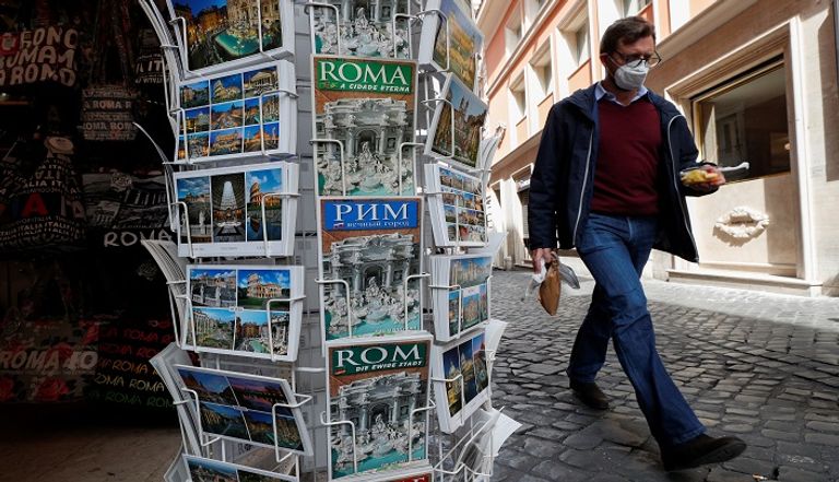 أشخاص يرتدون كمامات للوقاية من كورونا في روما