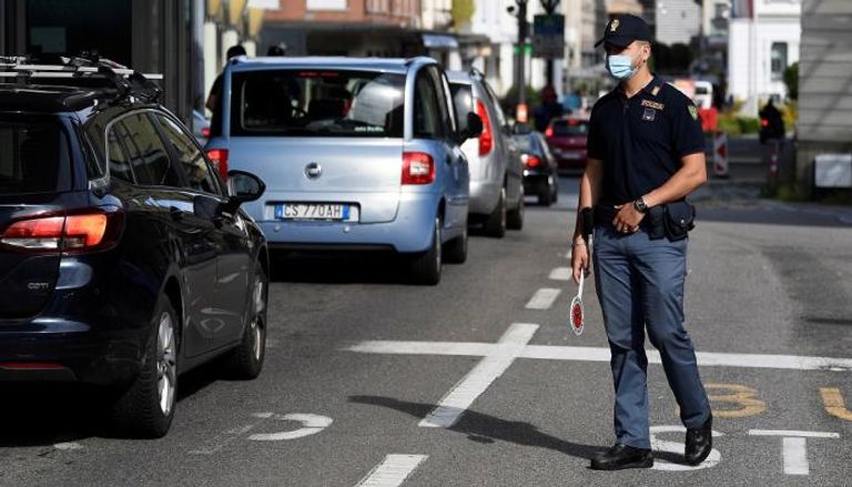رجل مرور يرتدي كمامة للوقاية من كورونا في إيطاليا