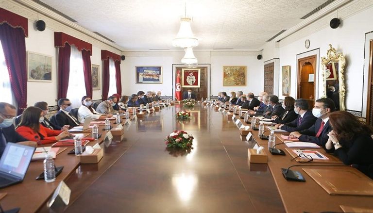 اجتماع الحكومة التونسية بشأن إجراءات كورونا رئيس الوزراء التونسي مرتديا الكمامة
