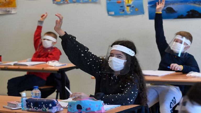 طلاب يتلقون التعليم ويرتدون كمامة للوقاية من كورونا العالم يحيي اليوم الدولي للمعلمين