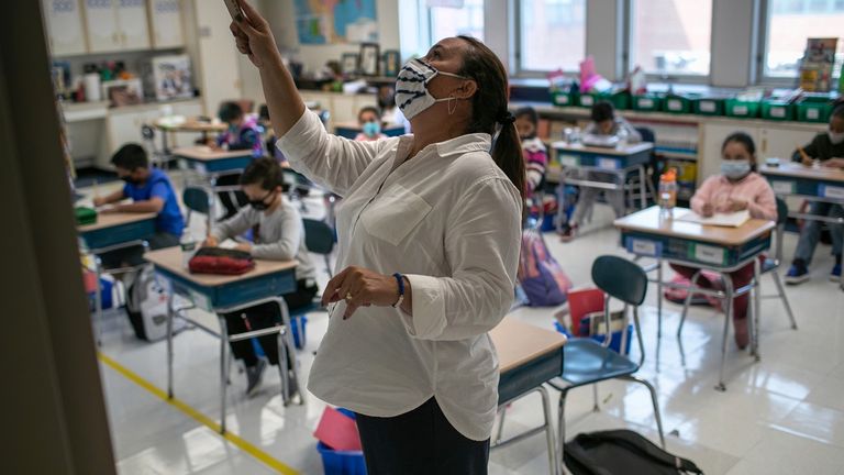 مدرسة ترتدي كمامة أثناء الفصل التعليمي للوقاية من كورونا العالم يحيي اليوم الدولي للمعلمين