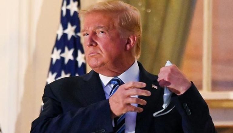 الرئيس الأمريكي ينزع الكمامة عن وجهه بعد وصوله البيت الأبيض- رويترز