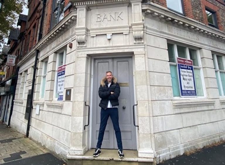 آدم ديرينج أمام مقر  بنك "أر بي إس" في مدينة أرمستون البريطانية آدم ديرينج رجل الأعمال البريطاني