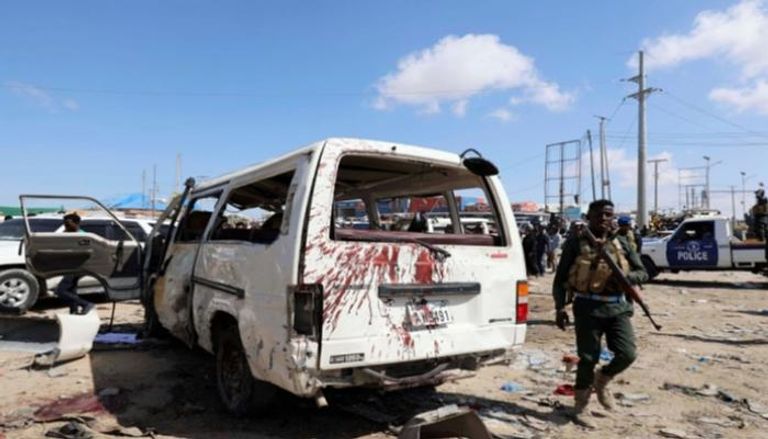 ضابط صومالي يسير بجوار سيارة مدنية في أعقاب انفجار - أرشيفية