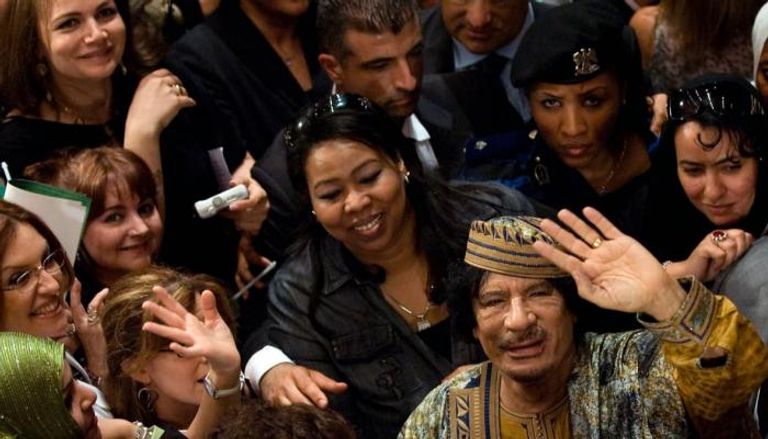 القذافي وسط مجموعة من الحارسات الشخصيات