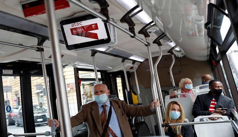 أشخاص يرتدون كمامات للوقاية من كورونا في روما