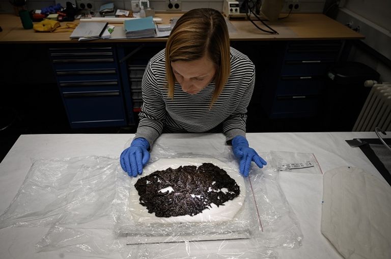 خبيرة في حفظ القطع الأثرية تتفحص سلة من الصوف اكتشفت في جبال الألب