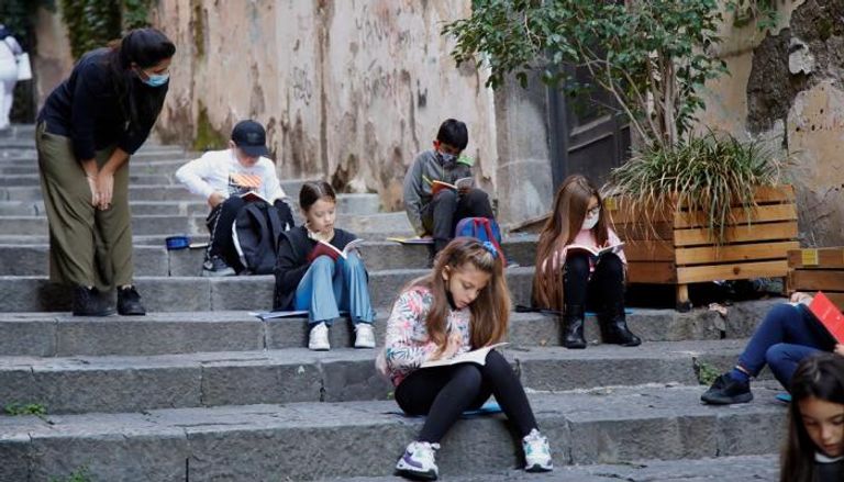 التلاميذ يجلسون على درج في شارع بوسط نابولي