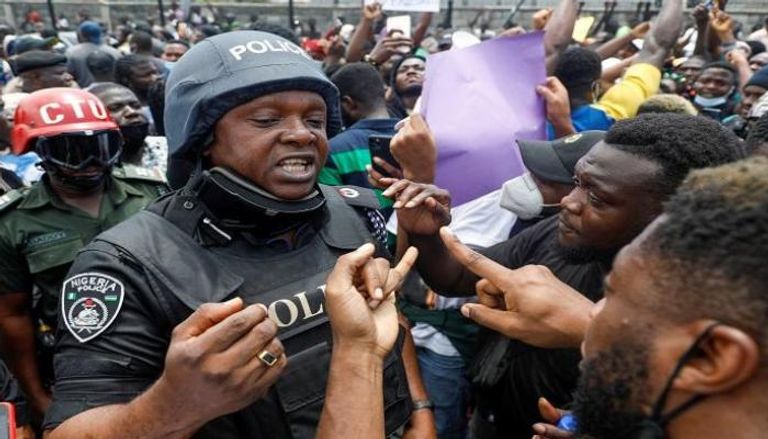 رجل شرطة بين المتظاهرين في نيجيريا