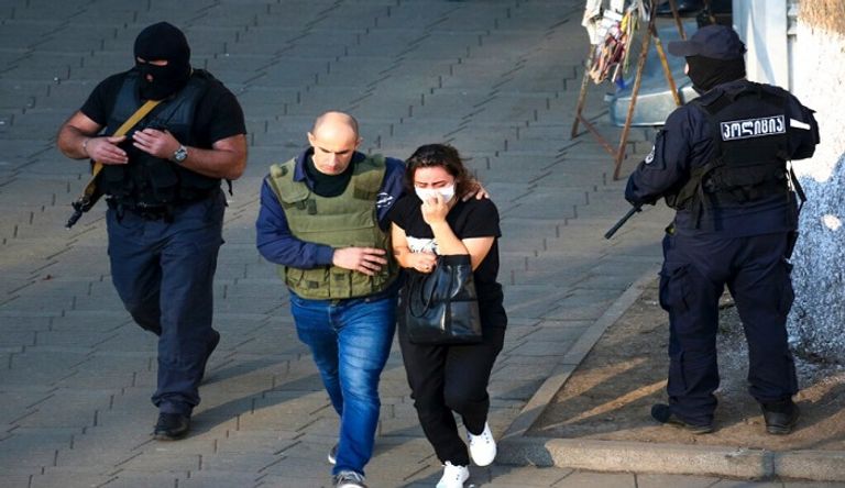 محتجز الرهائن يظهر بزي عسكري حاملا لقنبلة يدوية