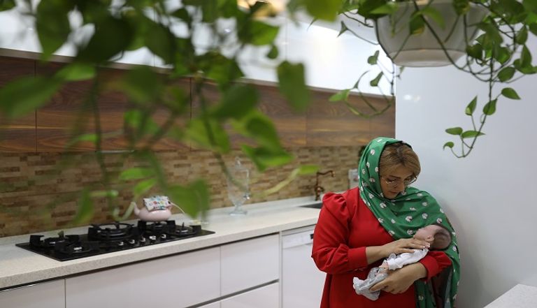 إيرانية تحمل دمية شبيهة بالأطفال