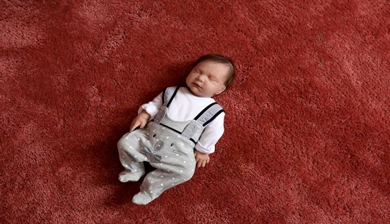 إيرانية تحمل دمية شبيهة بالأطفال