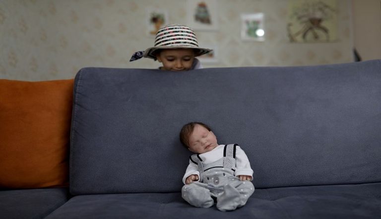 إيرانية تحمل دمية شبيهة بالأطفال