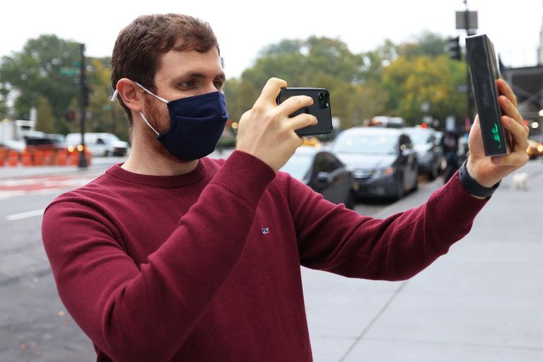 يلتقط بن راتنر صورة لجهاز iPhone الجديد بعد أن كان أول عميل يخرج من متجر Apple Fifth Avenue في 23 أكتوبر 2020 في مدينة نيويورك يلتقط