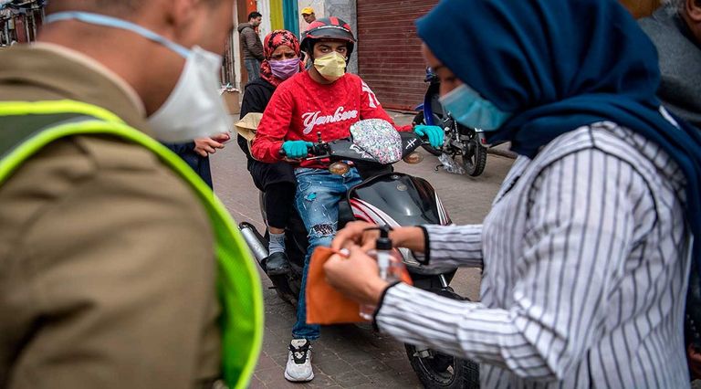 سيدتان تضعان كمامة عند المرور في ساحة مطار عربي