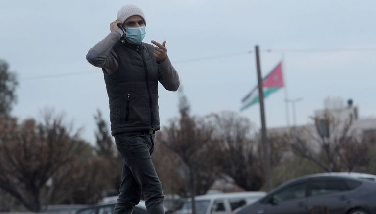 سيدتان تضعان كمامة عند المرور في ساحة مطار عربي