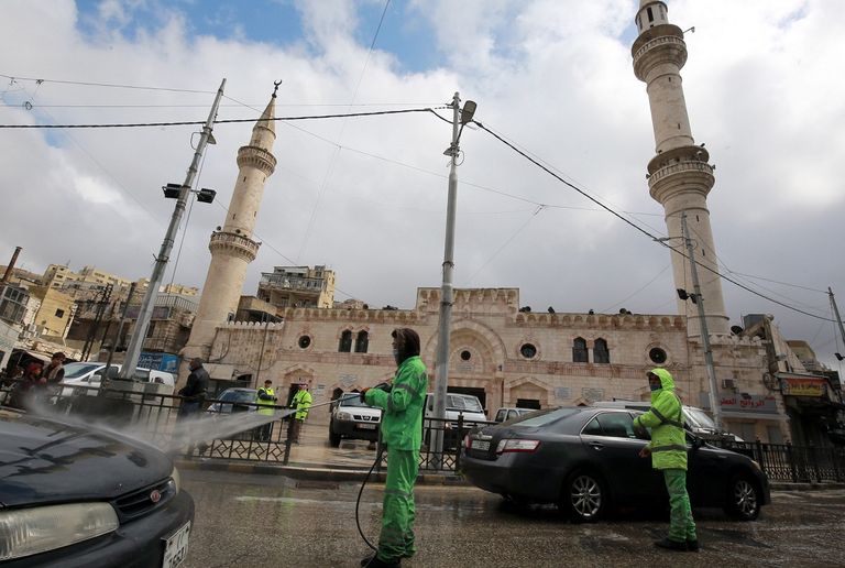 سيدتان تضعان كمامة عند المرور في ساحة مطار عربي