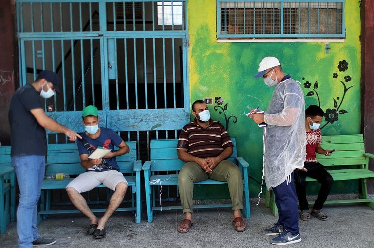 طالبتان ترتديان كمامتين وتحرصان على التباعد في غزة