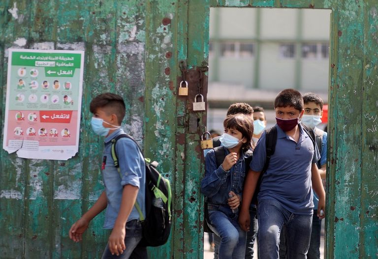 طالبتان ترتديان كمامتين وتحرصان على التباعد في غزة