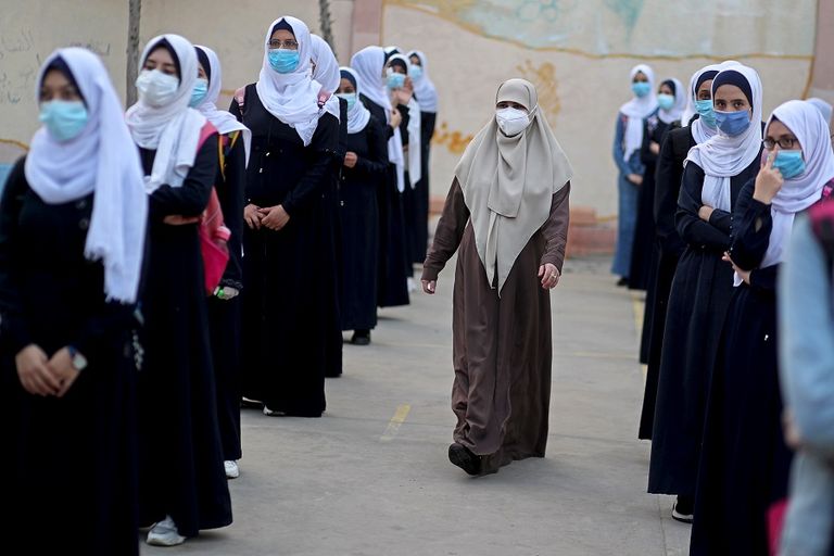 طالبتان ترتديان كمامتين وتحرصان على التباعد في غزة