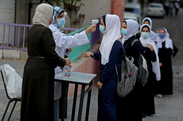 طالبتان ترتديان كمامتين وتحرصان على التباعد في غزة