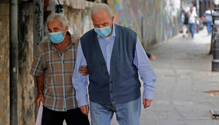 لبنانيان يرتديان الكمامة للوقاية من فيروس كورونا