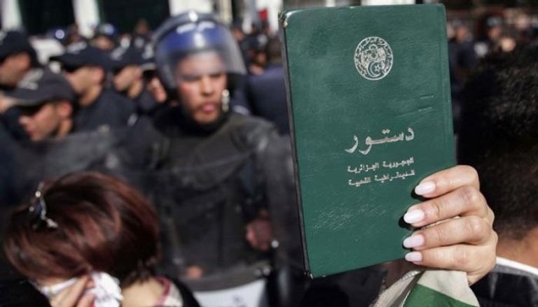 جزائرية ترفع الدستور في مظاهرات الحراك الشعبي - أرشيفية