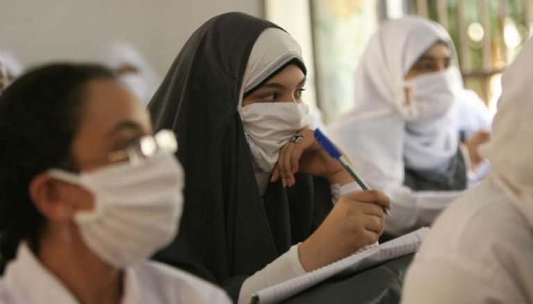 طالبات بأحد الصفوف الدراسية يرتدين الكمامات في مصر