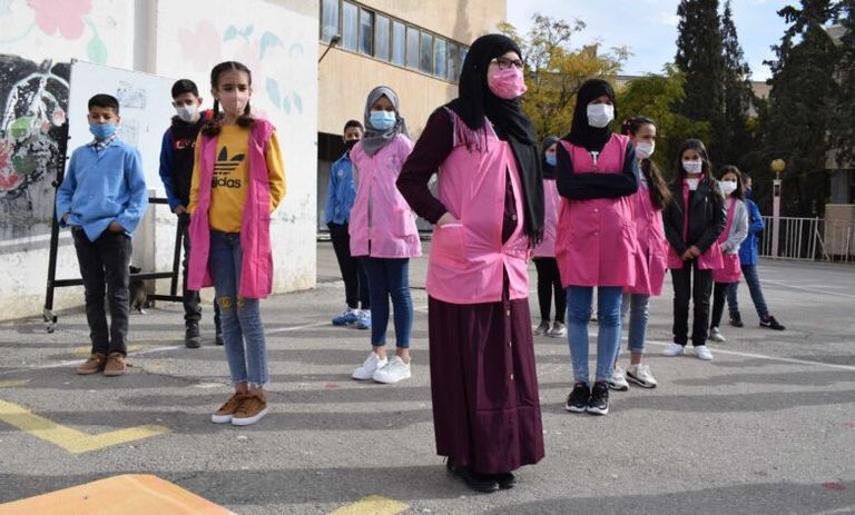 تلاميذ جزائريون بالكمامات طبيبان جزائريان في قسم خاص بحالات الإصابة بفيروس كورونا - أرشيفية