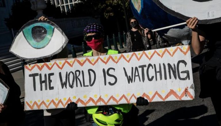 ناشطون من أجل المناخ يحملون لافتات لتعزيز جهود التصدي للأزمة المناخية العالمية