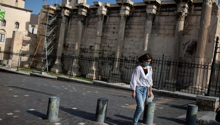 يونانية ترتدي الكمامة في شارع خلال فترة الإغلاق