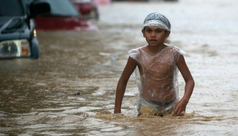 طفل يخوض في المياه التي خلفها الإعصار
