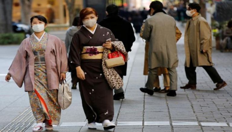 أشخاص يرتدون كمامات للوقاية من كورونا باليابان