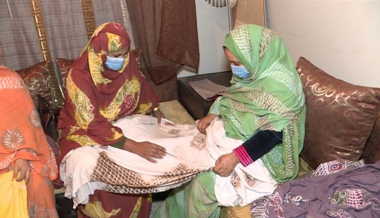 نساء في مدينة العُيون، تقوم بصنيع الملحفة المغربية