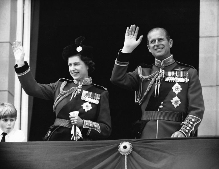 تحية الملكة إليزابيث الثانية ودوق إدنبرة من شرفة قصر بكينجام خلال احتفال "تروبينج ذا كلر" عام 1979. مشهد من مسلسل