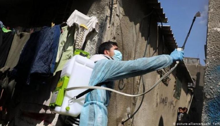 كادر طبي يعقم جدران منزل بغزة