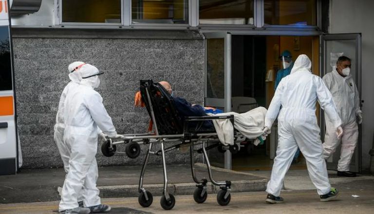 فريق طبي يرافق أحد المصابين بفيروس كورونا إلى المستشفى