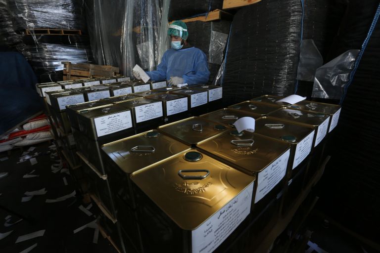 عمال فلسطينيون يجهزون أول شحنة زيت للتصدير